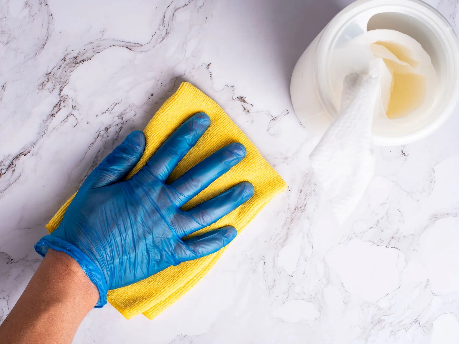 A gloved hand wiping a surface clean during business hours.