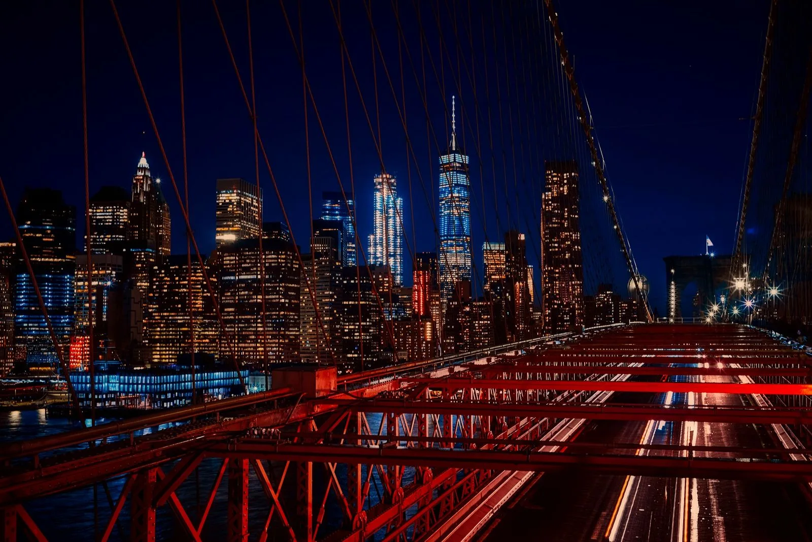 The Manhattan skyline and Brooklyn Bridge at night.