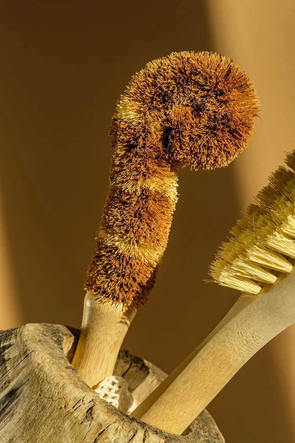 Natural-fiber cleaning brushes in a wooden holder.