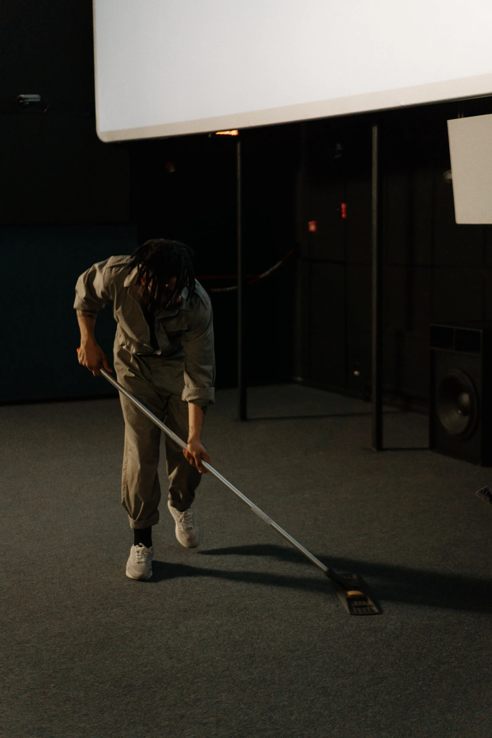 A cleaner attending to a large commercial space, working in a calm, focused way.