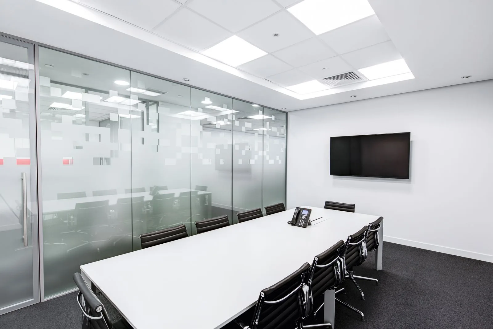 An immaculate, glass-walled boardroom.